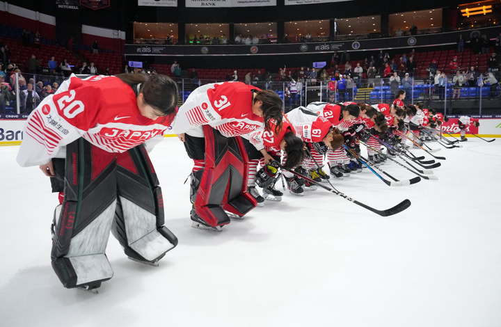 Team Japan bows in a line on the ice.