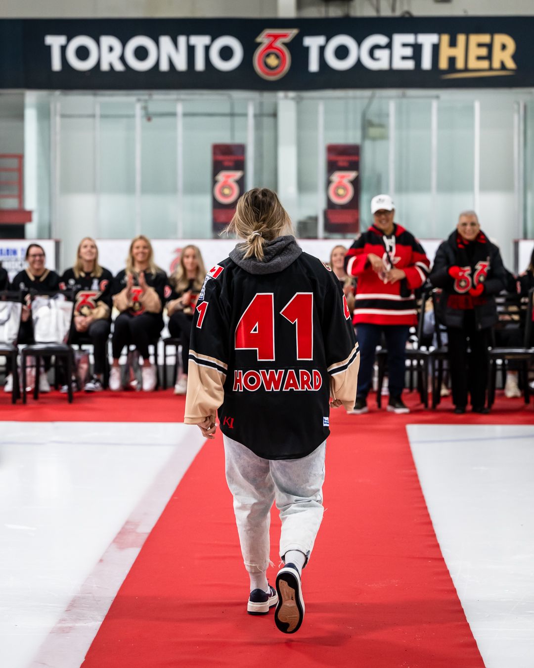 Brittany Howard walking towards her already seated teammates at the Isobel Cup celebration