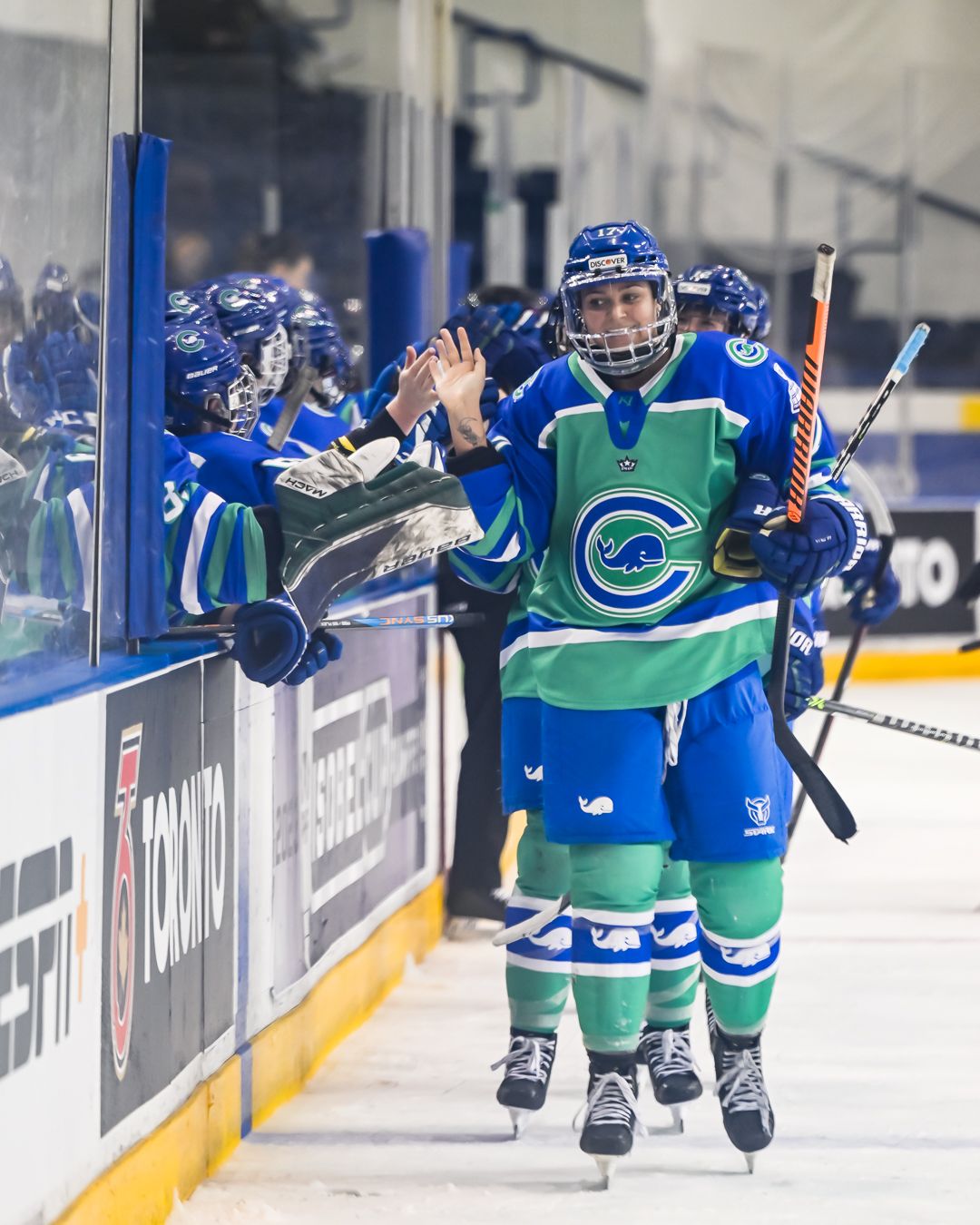 Taylor Girard skates by the CTW bench with her right glove off for high fives