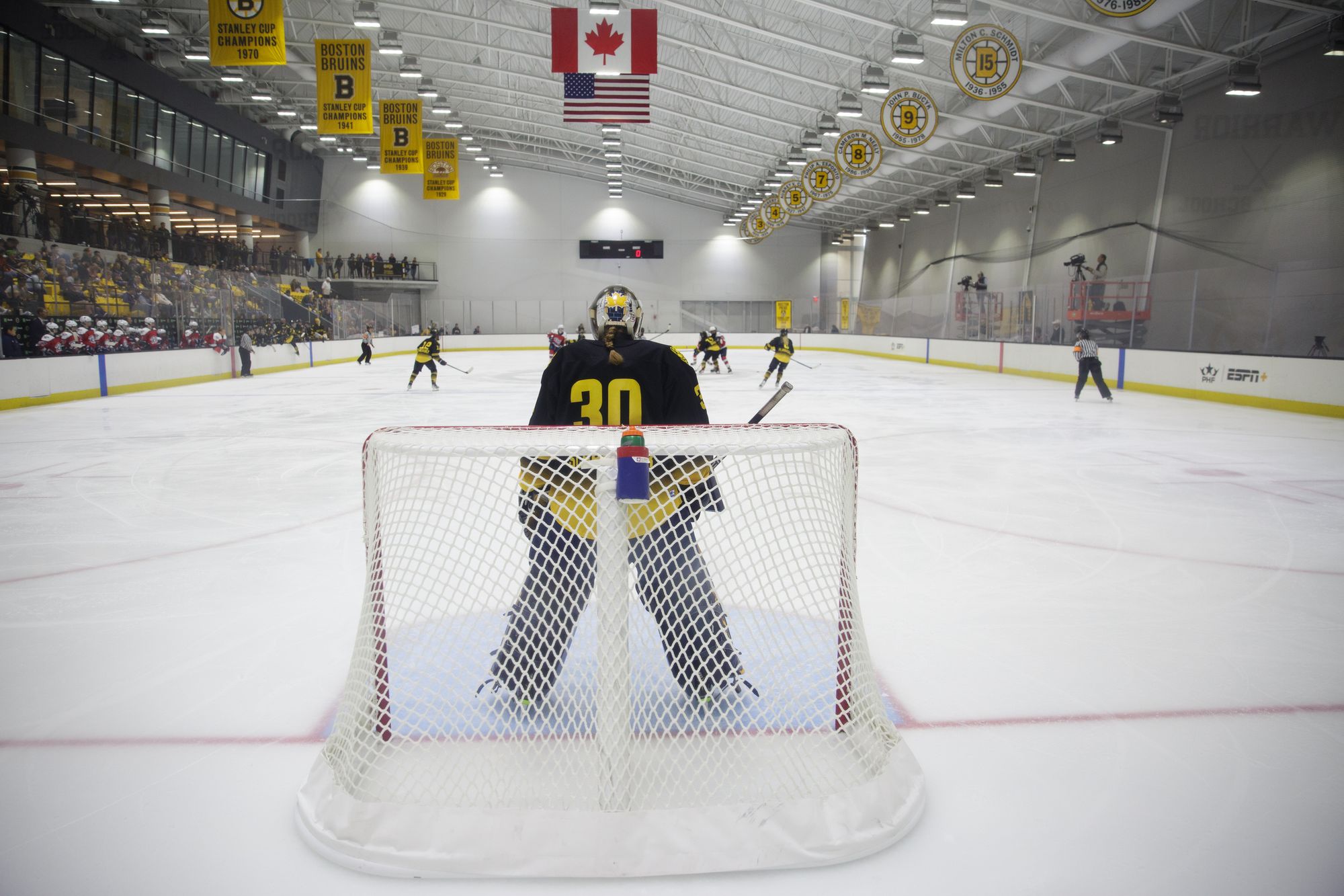 Photo taken from behind Corinne Schroeder's net as she stands, waiting for play to approach.