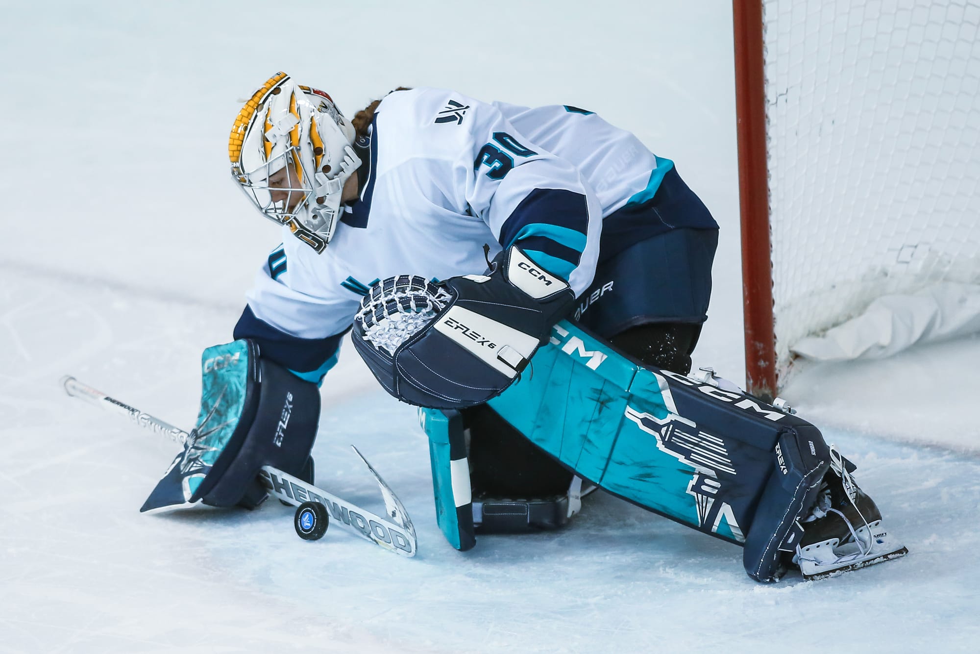 Corinne Schroeder, wearing her white away uniform and teal New York pads, makes a save in a game against Toronto.