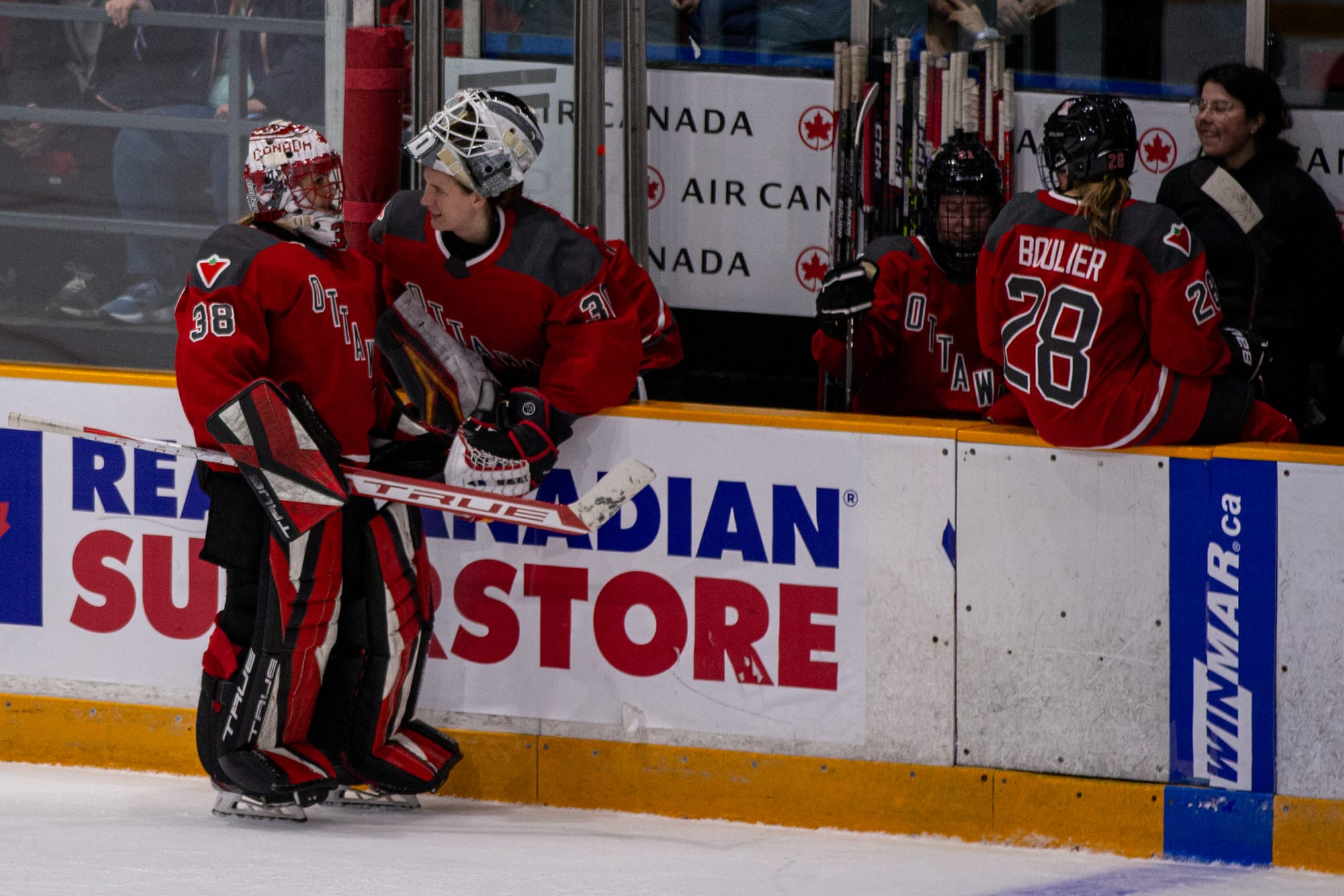 Goalies Maschmeyer and Abstreiter talk to each other at the bench during a game. 