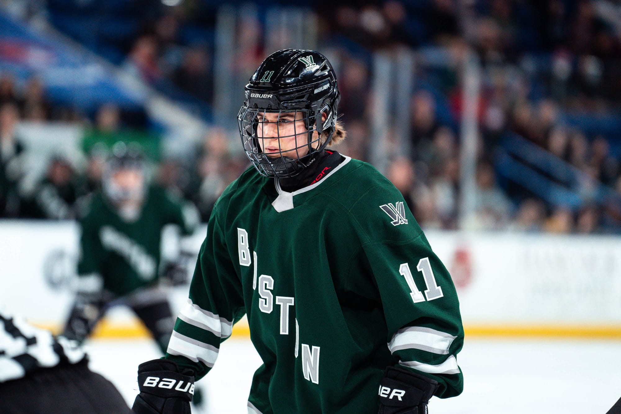 Alina Müller, wearing a green home uniform, prepares for a face-off.