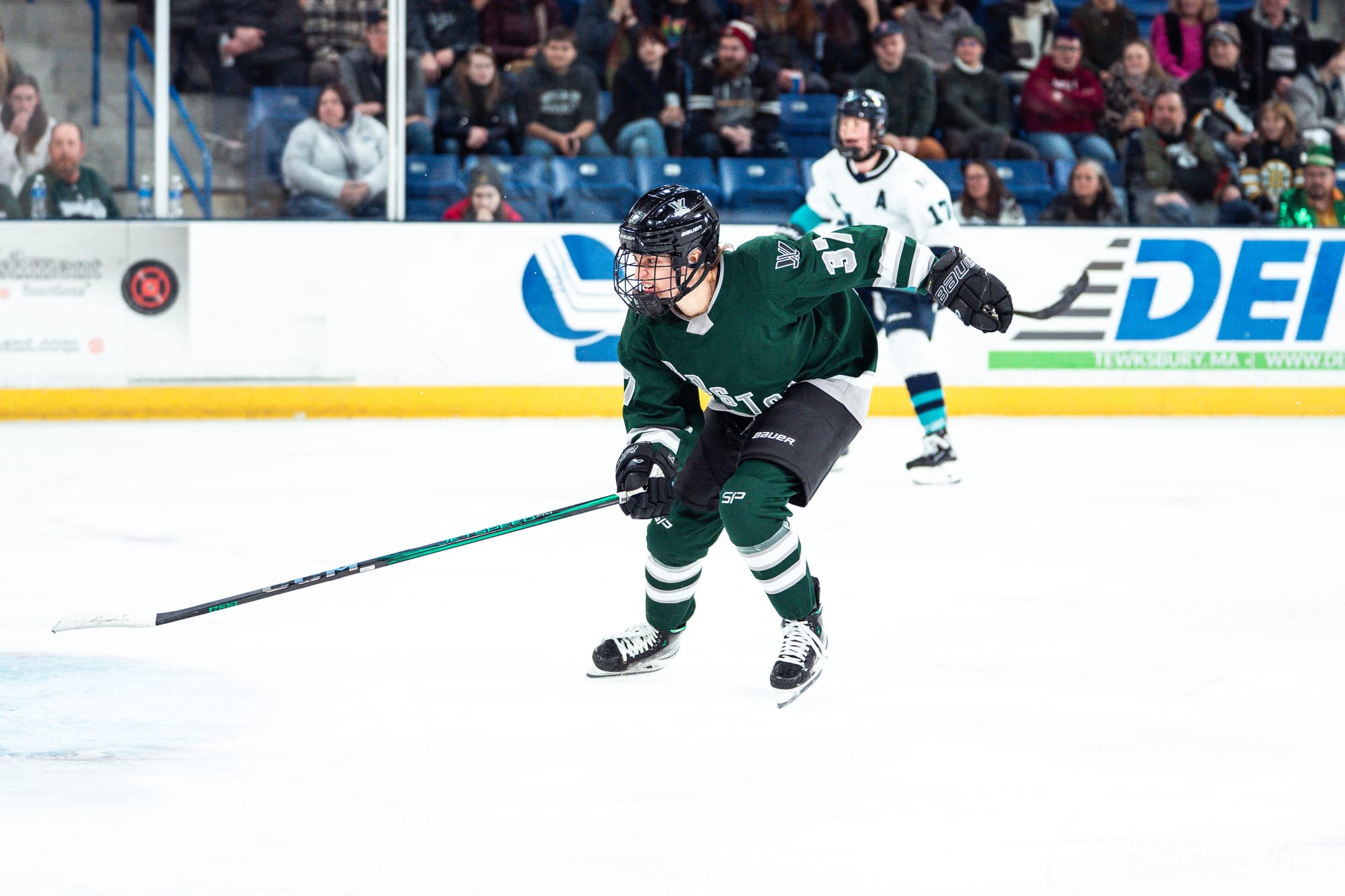 Theresa Schafzahl, wearing a green home uniform, hunts the puck during a game.
