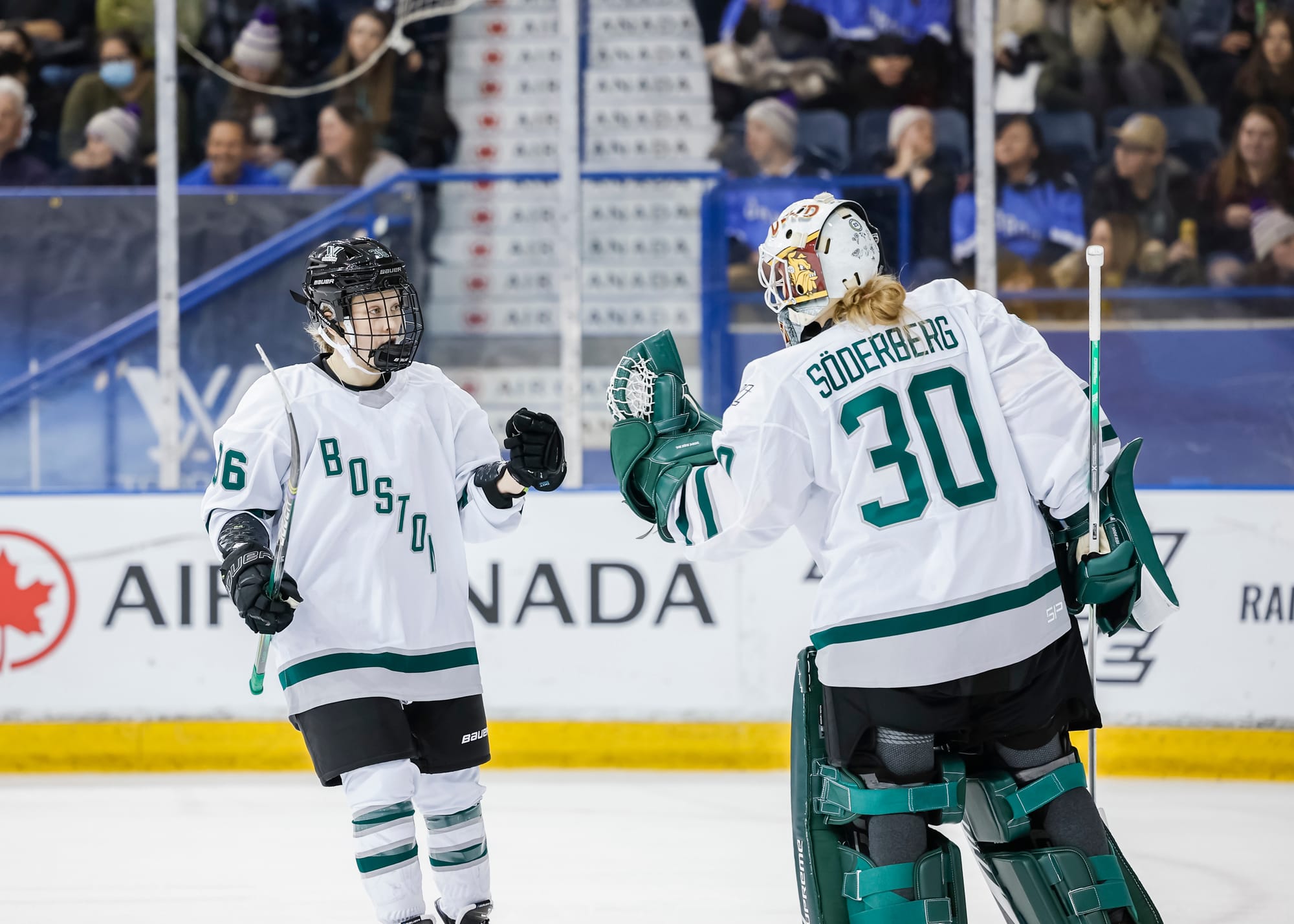 Wearing their white away uniforms, Loren Gabel goes in for a fist bump with Emma Söderberg during a game against Toronto. 