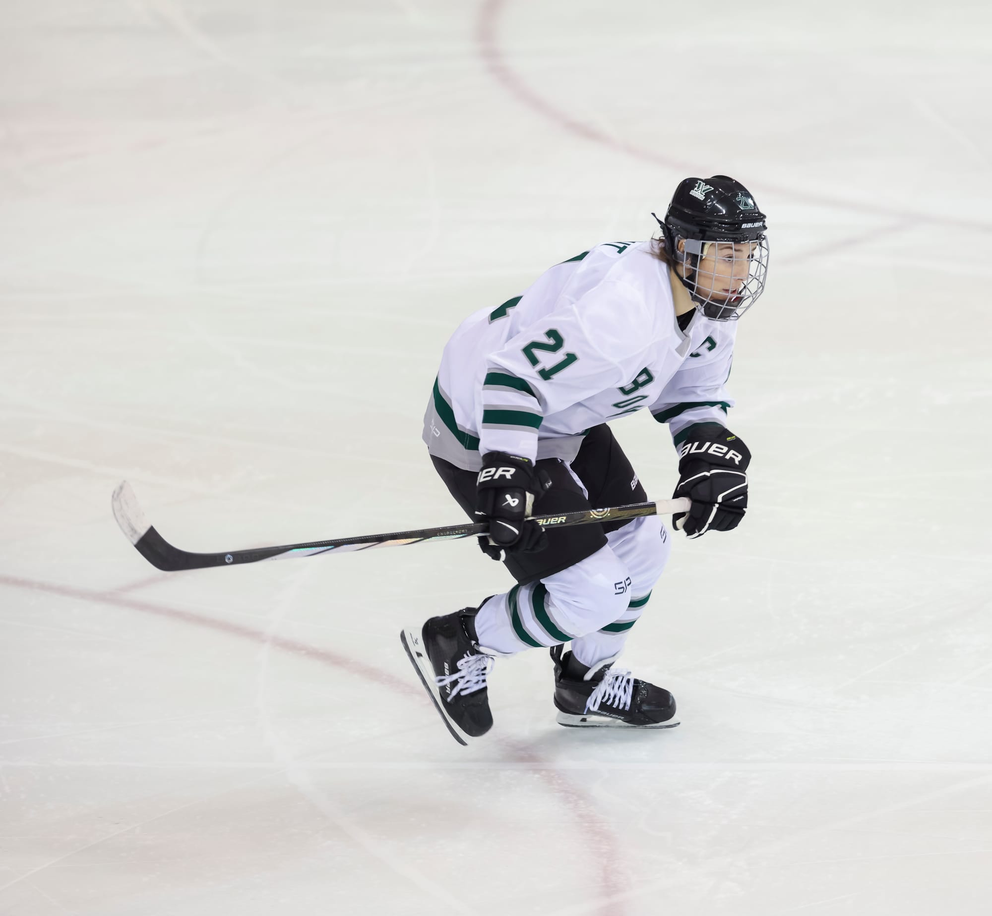 Hilary Knight, wearing a white home uniform, hunts the puck during a game. 