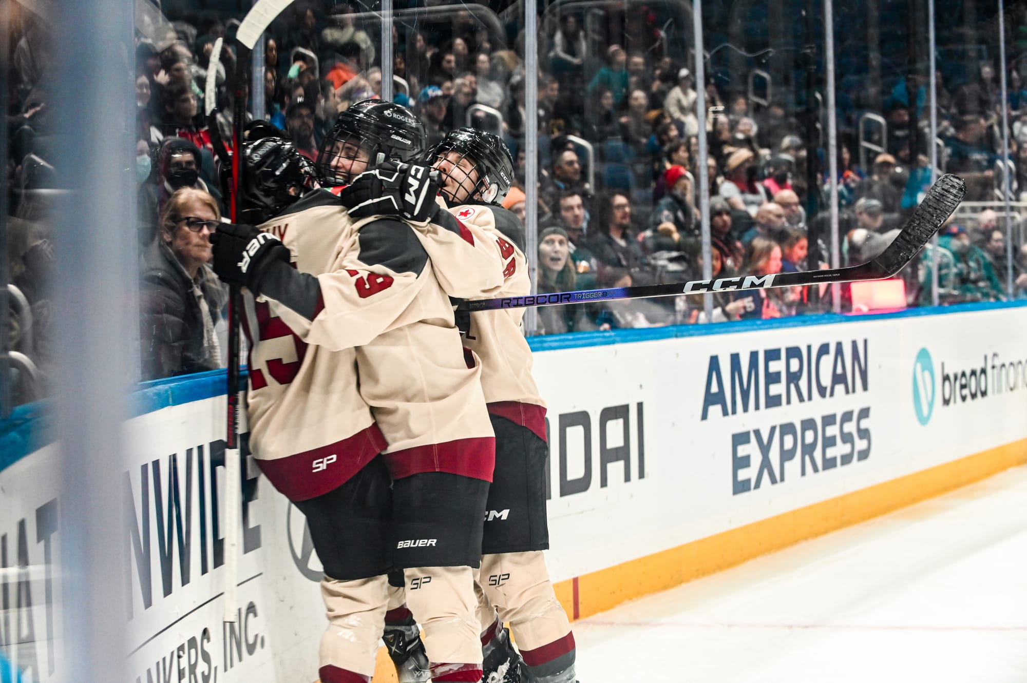 Members of PWHL Montréal, wearing their cream away uniforms, celebrate a goal against New York.