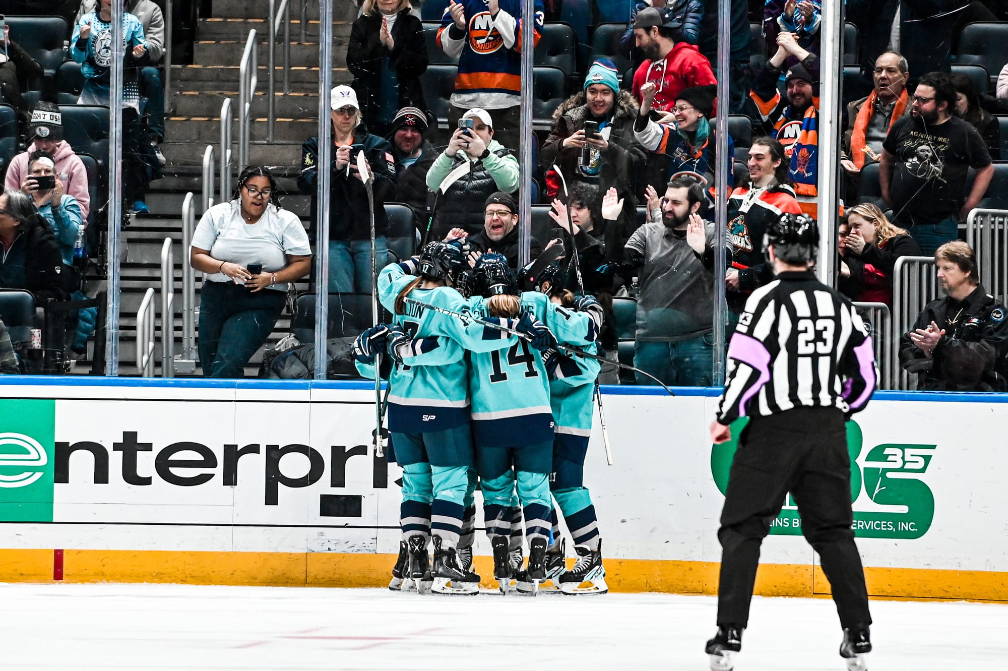 Members of PWHL New York, wearing their teal away uniforms, celebrate a goal against Montréal.