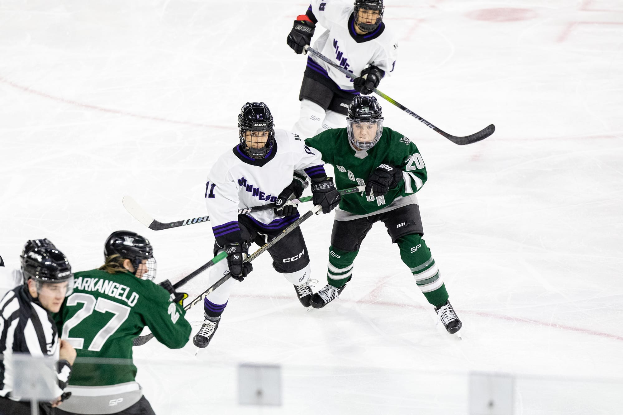 Hannah Brandt, wearing a green home uniform, and Sophia Kunin, wearing a white away uniform, battle for positioning. 