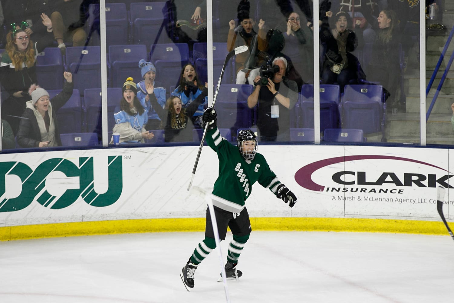 An elated Hilary Knight, wearing a green home uniform, celebrates her game-winning goal in overtime.