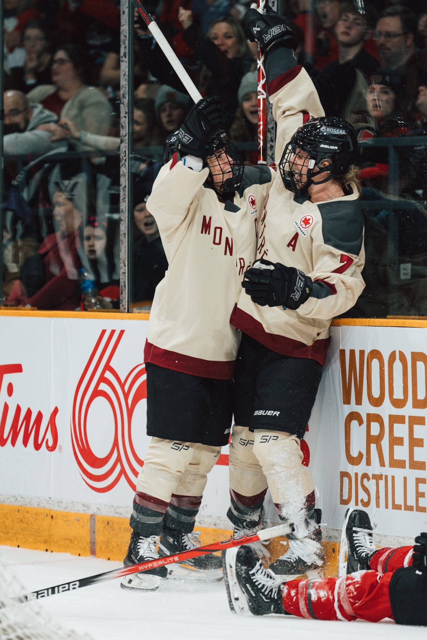 Laura Stacey celebrates her game-tying goal with Marie-Philip Poulin in their cream away uniforms.