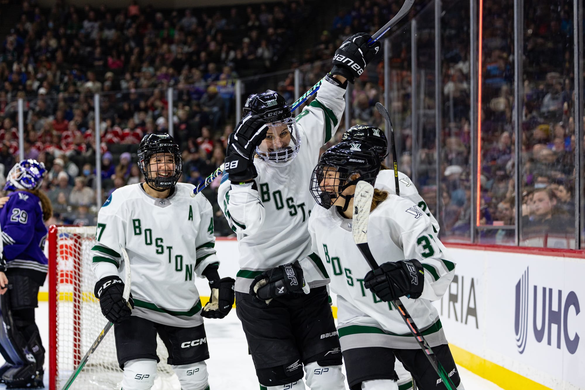 Theresa Schafzahl celebrates her goal with her teammates. All are wearing whit away uniforms.