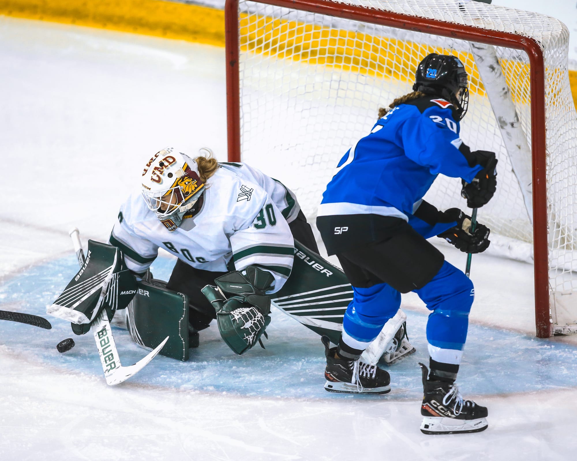 Emma Söderberg, wearing her UMD mask, white away uniform, and green Boston pads, makes a save against Toronto. 