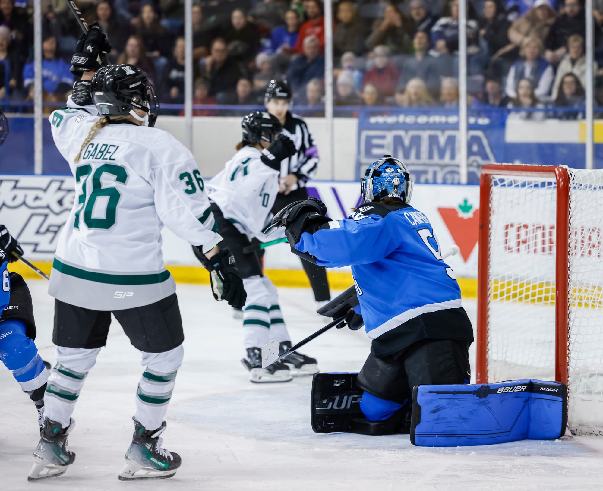 Loren Gabel, wearing a white away uniform, celebrates her goal against Toronto in front of Kristen Campbell, wearing her blue home pads and uniform.