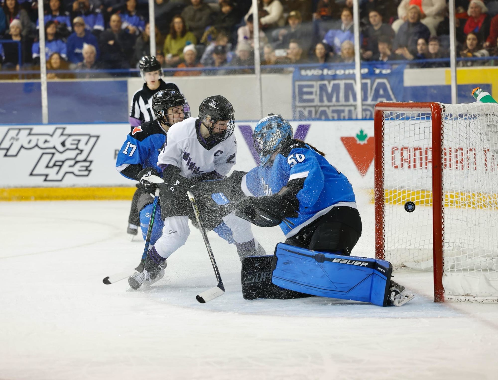 Kendall Coyne Schofield, wearing her white away uniform, comes to a stop as she scores against Toronto.