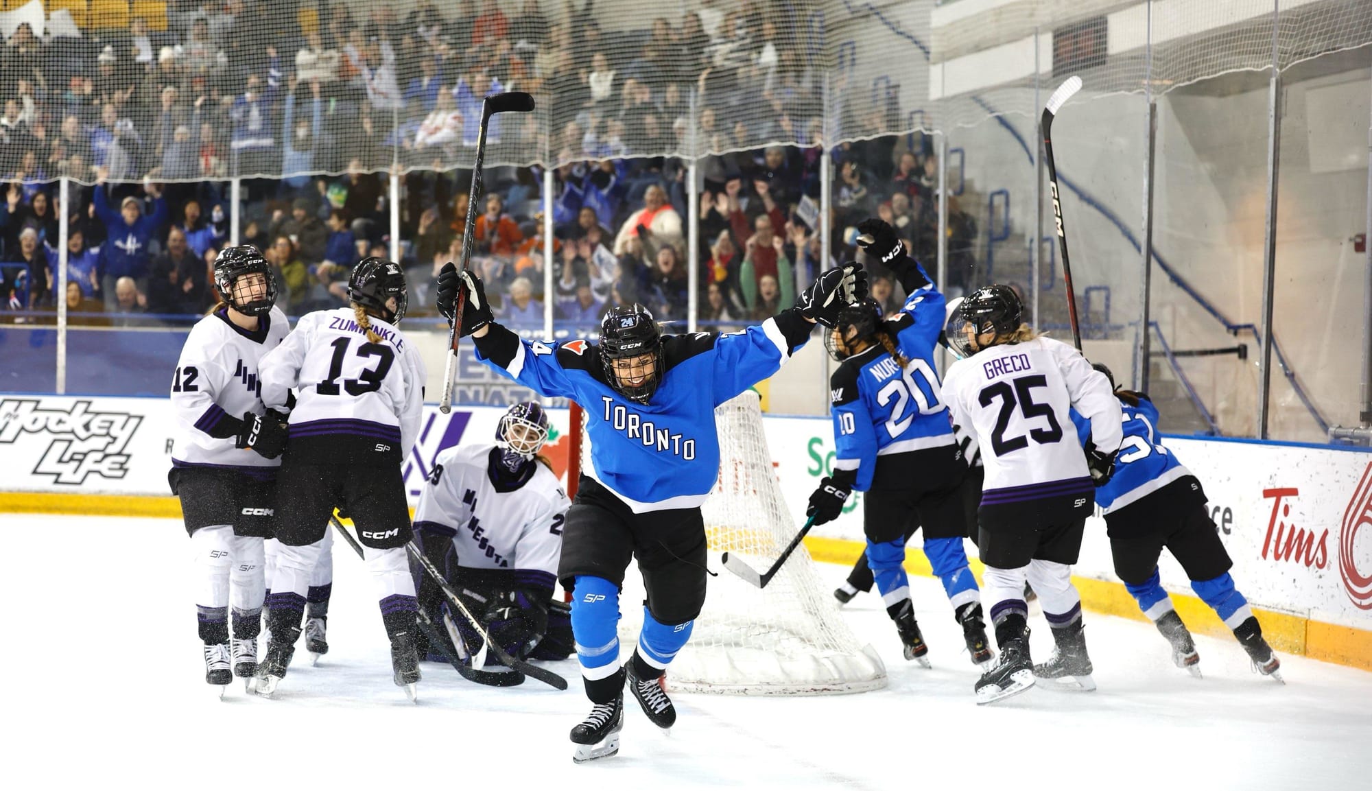 Natalie Spooner, wering her blue home uniform, celebrates her goal against Minnesota.