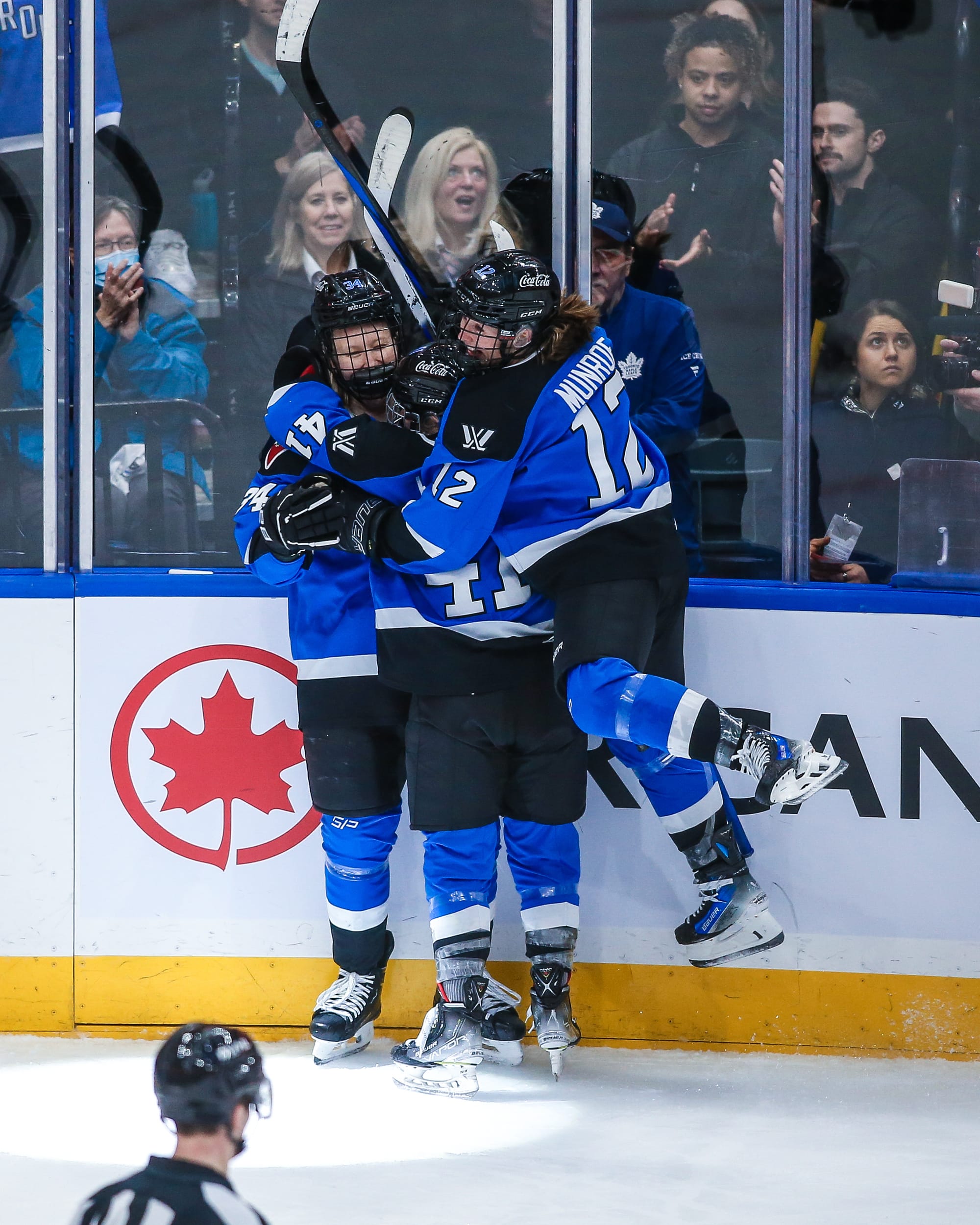 Toronto players, wearing blue home uniforms, celebrate a goal against Montréal.