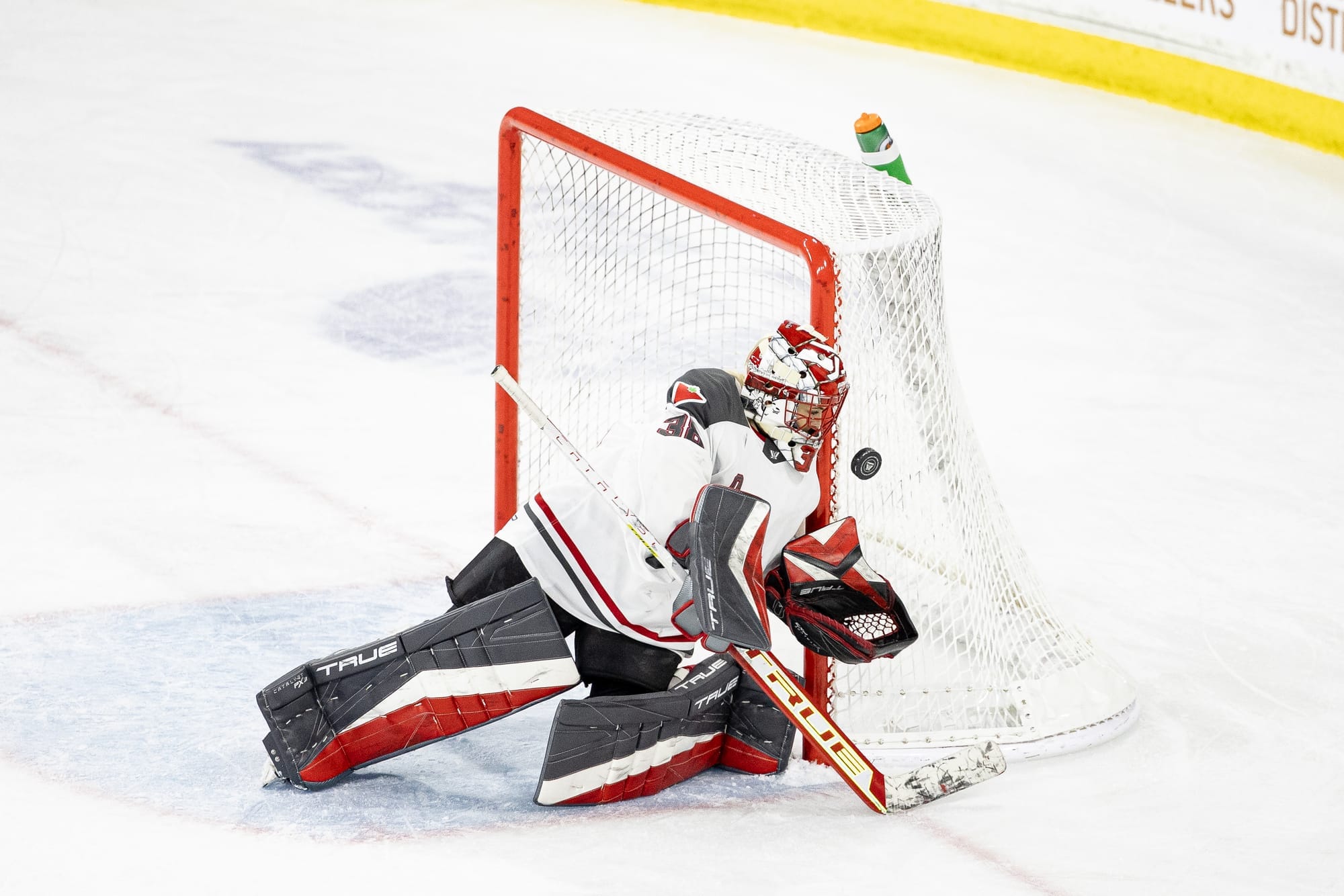 Emerance Maschmeyer makes a save against Boston. She is wearing her black/white/red pads, red/white Ottawa mask, and white away uniform, 