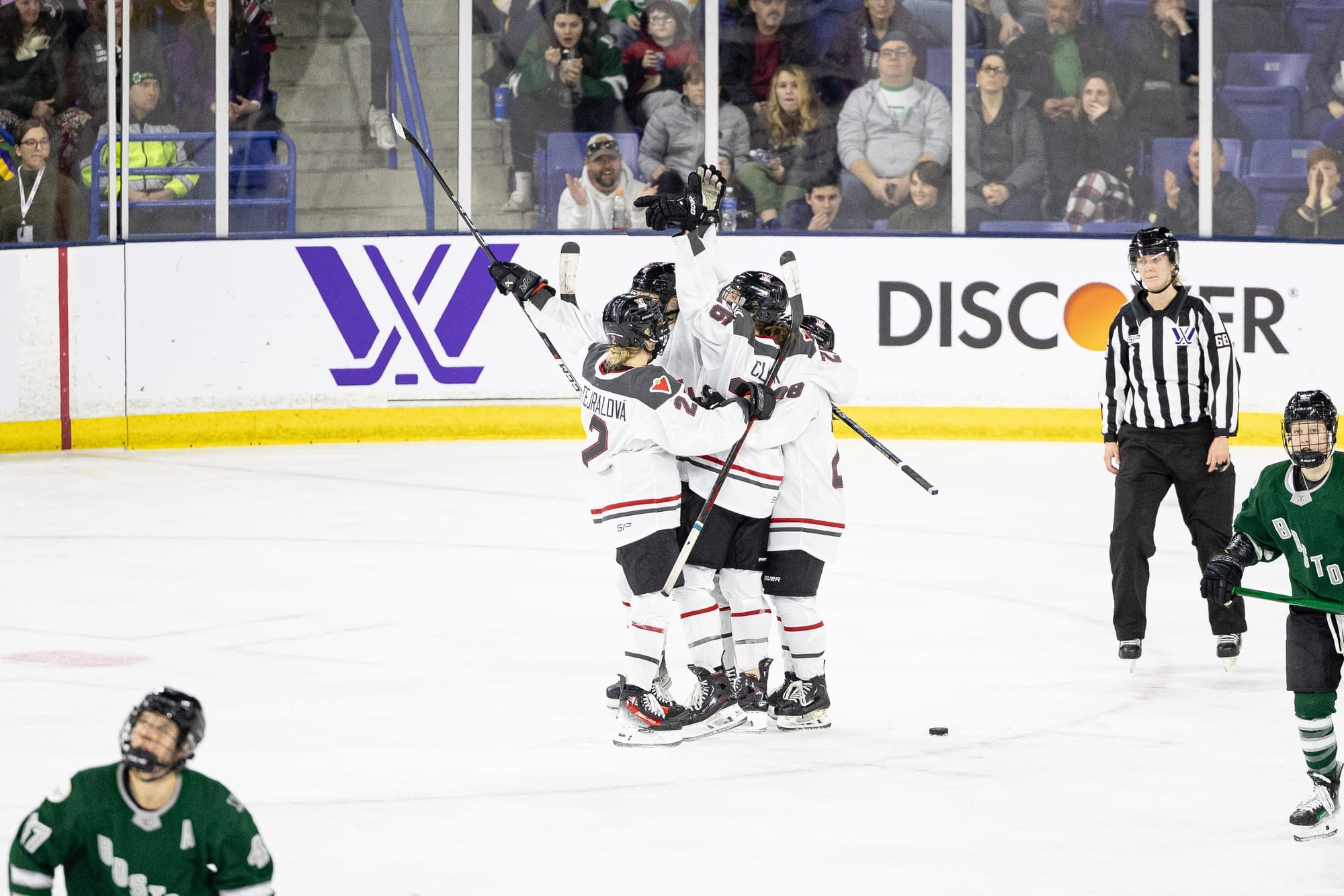 Ottawa players, wearing their white away uniforms, celebrate a goal against Boston. 