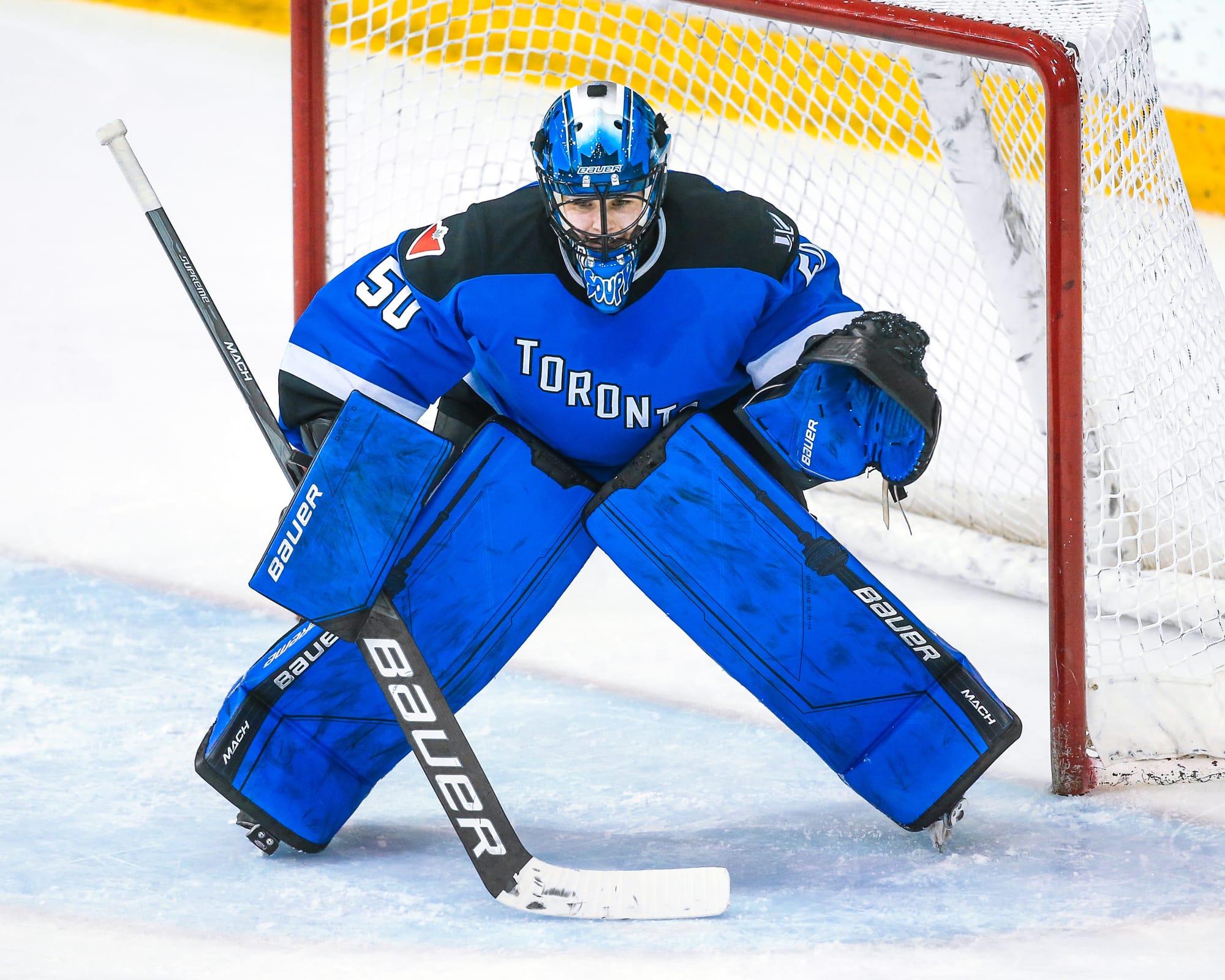 Kristen Campbell prepares to make a save. She is wearing her blue Toronto mask and gear, and a blue home uniform.