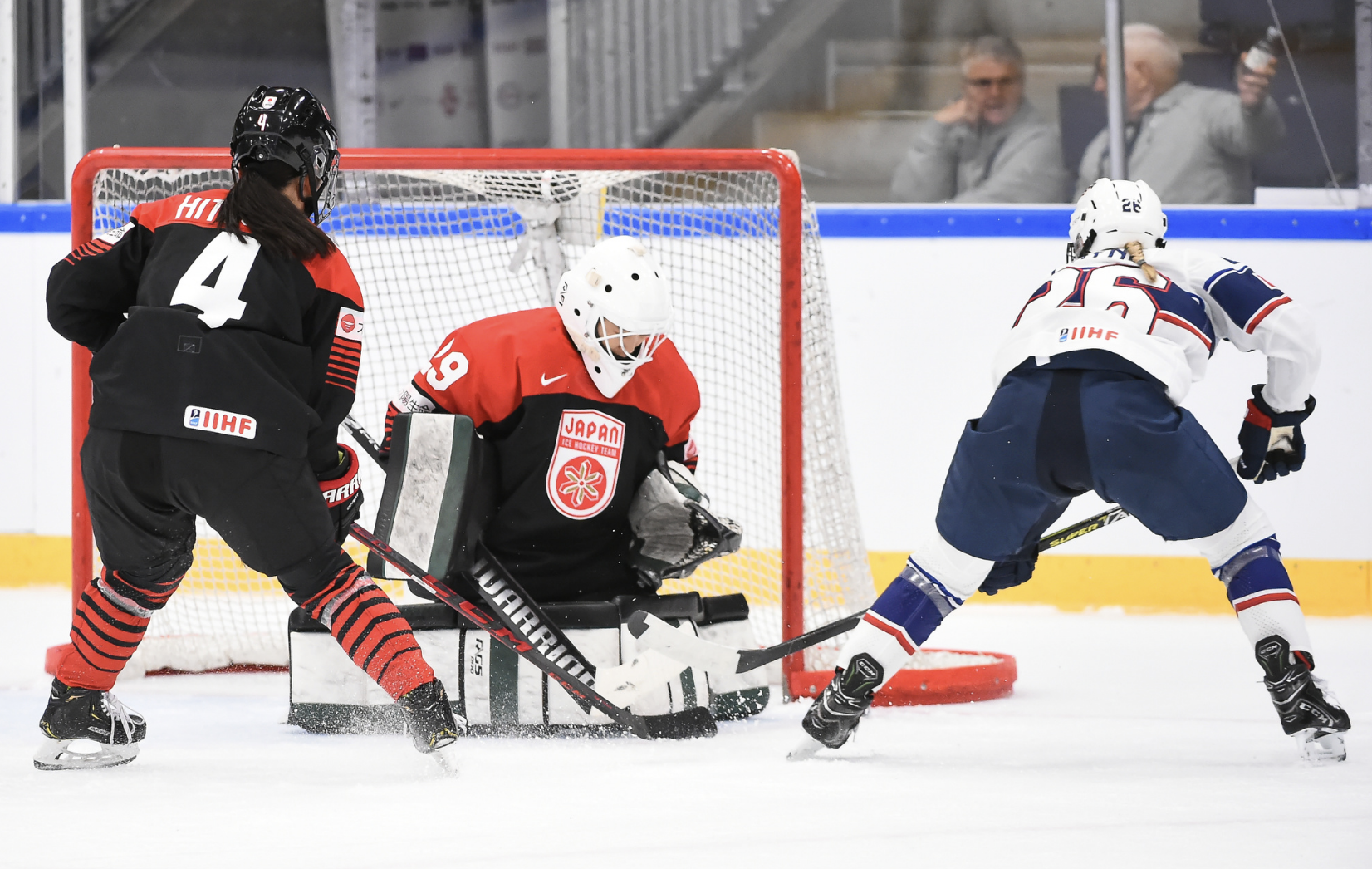 Coyne Schofield is just off the left corner of the net shooting on Masuhara, who is in the butterfly. Ayaka Hitosato defends out front. Coyne Schofield is in white, while the Japanese players are in black and red.