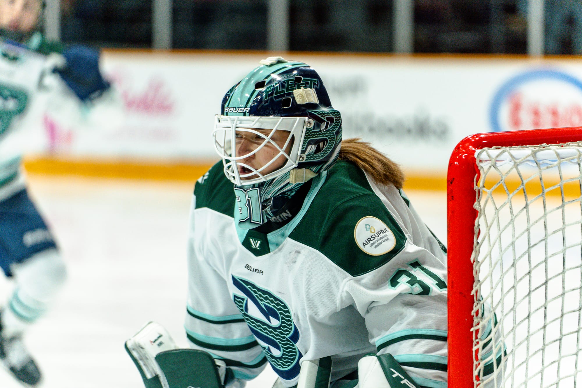 Frankel looks to her left, tracking the play during a game. She is wearing a white away uniform.