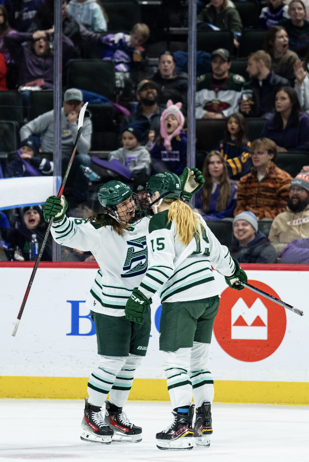 Brengman and Mobley stand close, smiling at each other as they open their arms to embrace. They are both wearing white away uniforms.