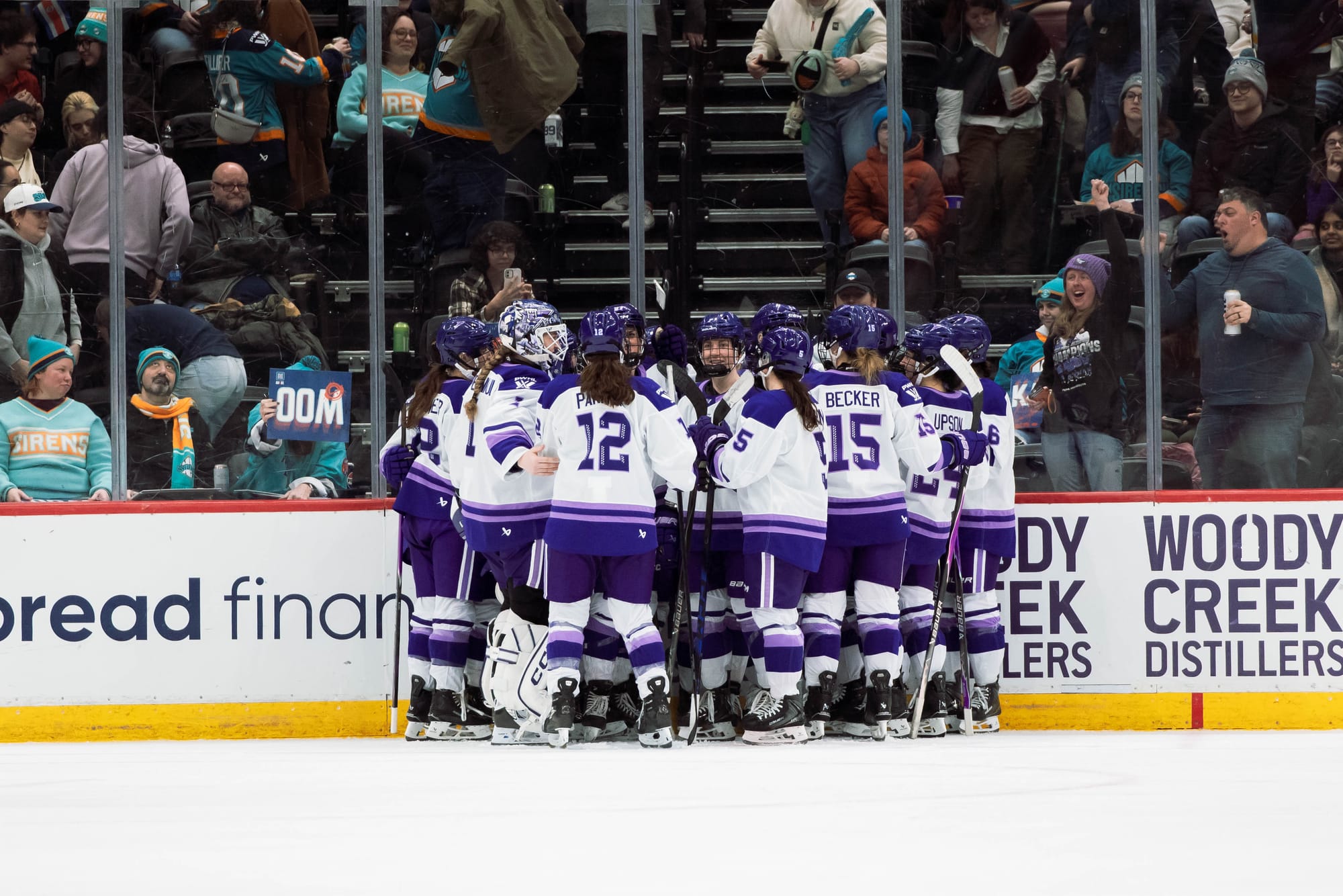 The entire Frost team forms a tight circle during their game against New York. They are all wearing white away uniforms.