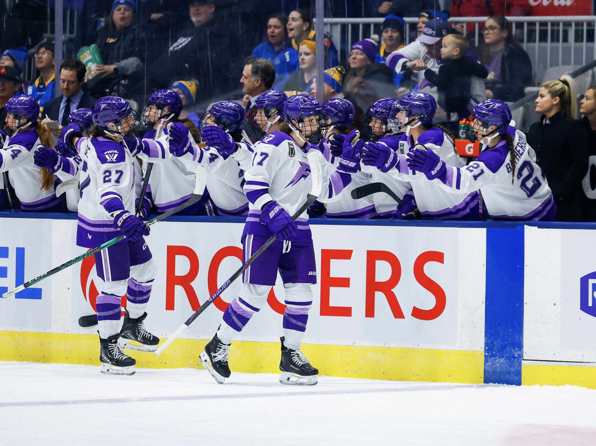 Curl-Salemme skates down the hand shake line at the bench, followed by Heise. They are all wearing white away uniforms.