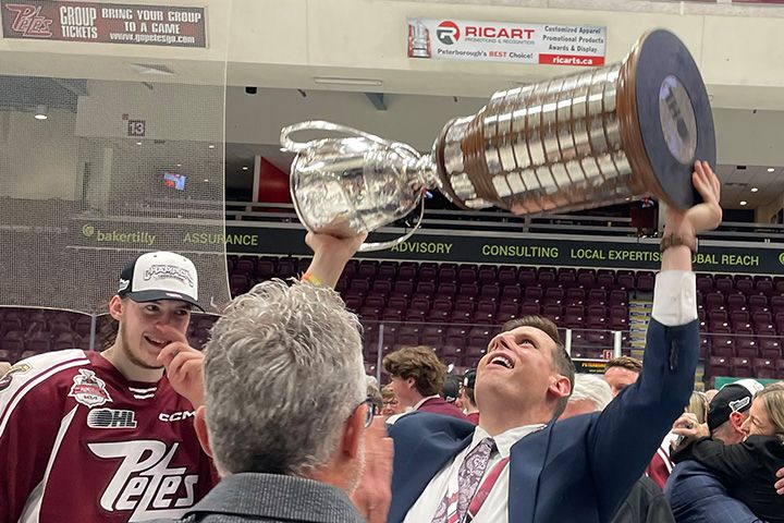 Burton Lee raises the memorial cup trophy above his head.