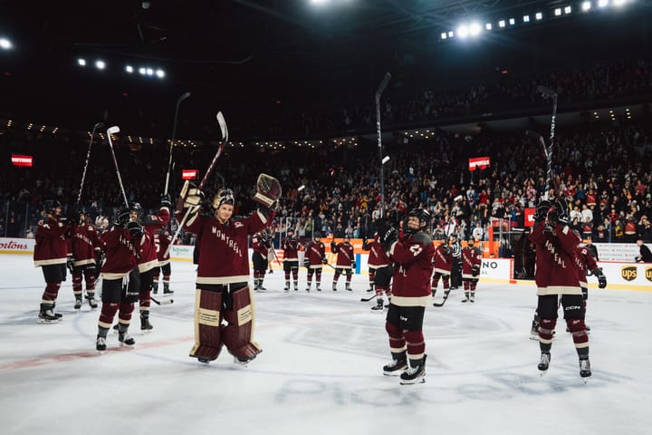 At center ice, Montréal celebrates their win over Ottawa with the home crowd in their maroon home uniforms.