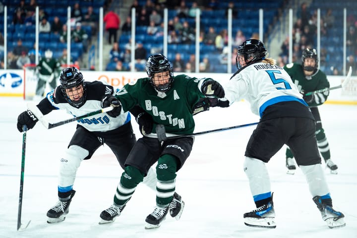 Jamie Lee Rattray, wearing a green home uniform, battles for positioning with Toronto players wearing white away uniforms.