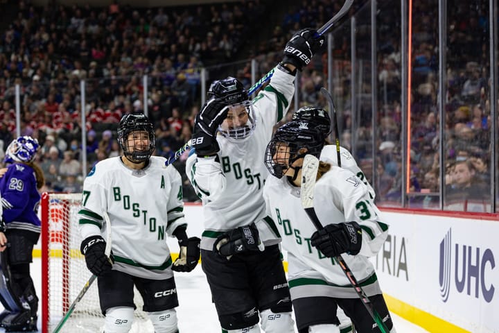 Theresa Schafzahl celebrates her goal with her teammates. They are wearing their white away uniforms.