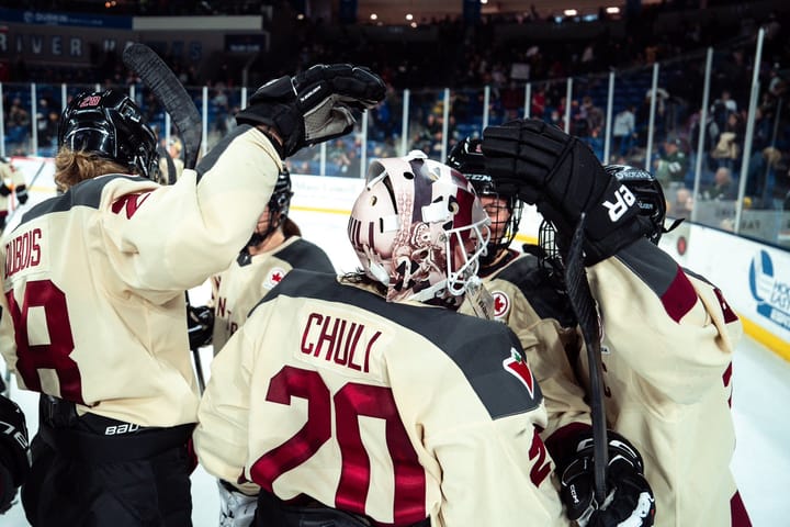 In their cream away uniforms, teammates celebrate with Elaine Chuli after their win against Boston.