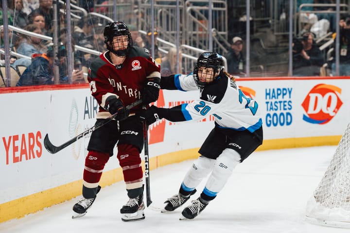 Nurse shoves Ambrose behind the net. Ambrose is upright wearing maroon, Nurse is more hunched over wearing white