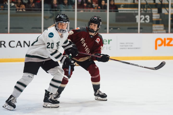 Hannah Brandt battles for positioning with Sarah Bujold. Brandt is wearing white, while Bujold is in maroon.