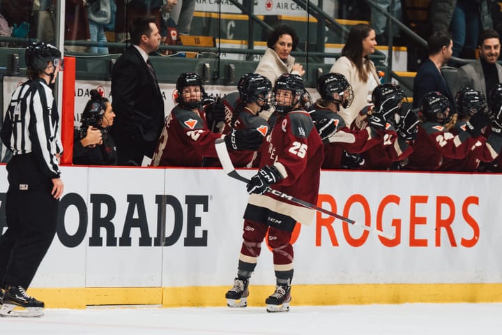 Mélodie Daoust celebrates her goal against Boston. She is going down the bench handshake line in a maroon home uniform.