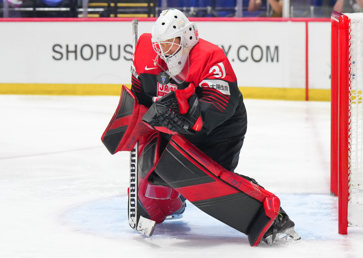 Japanese goaltender Riko Kawaguchi saves a puck against her chest during a game.