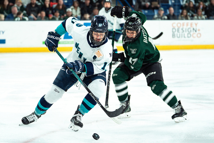 Rattray (right in green) attempts to get the puck from Shelton (left in white). Rattray is preparing to poke it away.