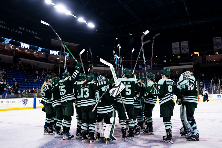 The Fleet gather at center ice to salute the crowd hug and partake in a whole group hug. They are all wearing green home uniforms.